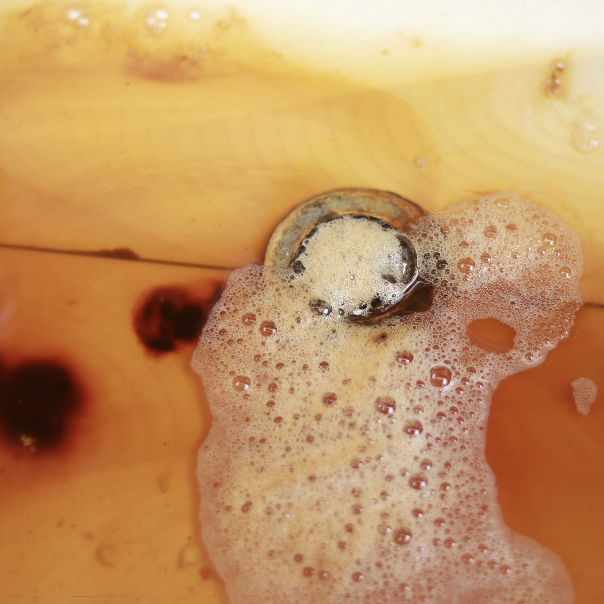 Suds draining in a rusted sink