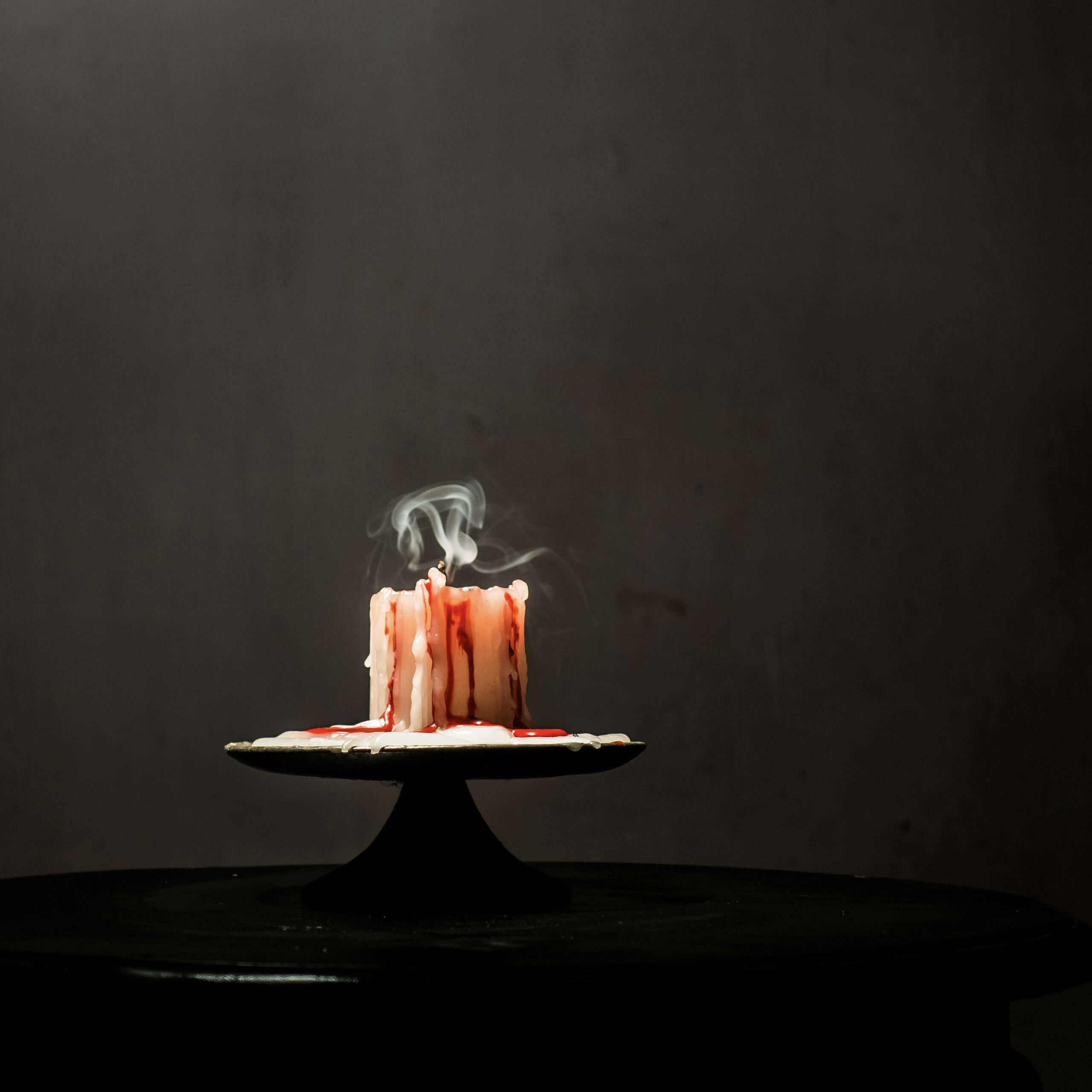 White cake, melted red candle, smoke from candle