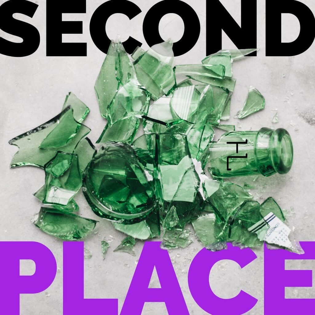 Second Place over a broken green bottle